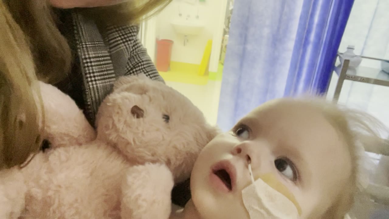 Lily resting close to her mum, a soft teddy between them